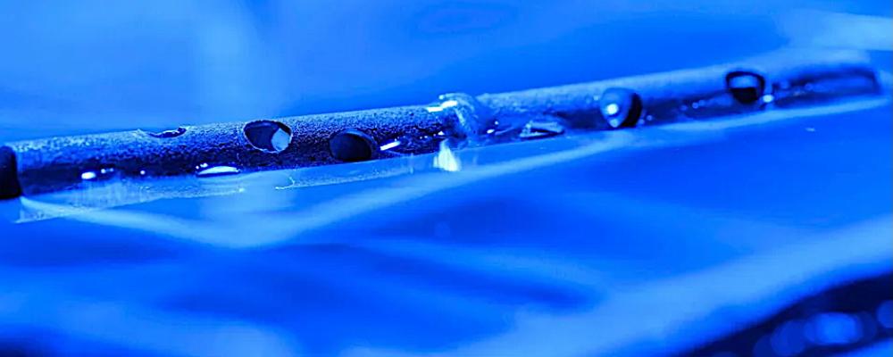 Metal treated with micro- and nanostructures can float on water, even after being drilled with holes. Foto: The University of Rochester