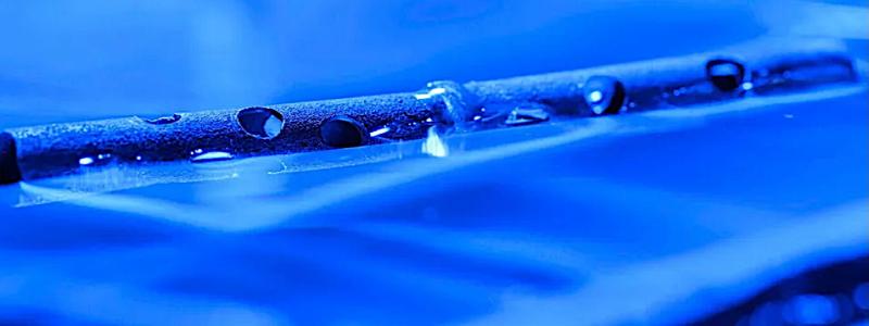 Metal treated with micro- and nanostructures can float on water, even after being drilled with holes. Foto: The University of Rochester