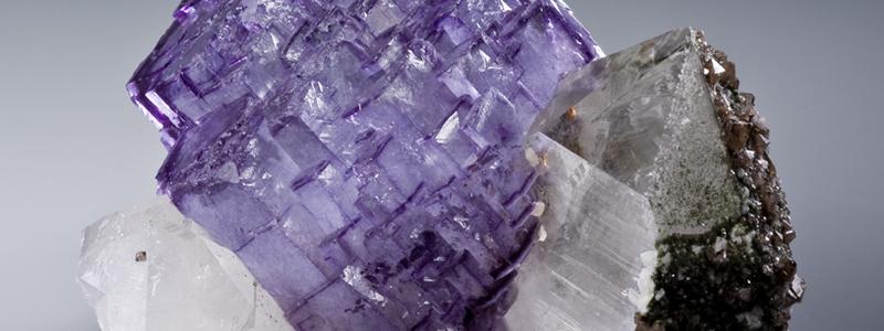 Freestanding purple fluorite cluster between two quartzes. Photo: Rob Lavinsky, iRocks.com/Wikimedia Commons
