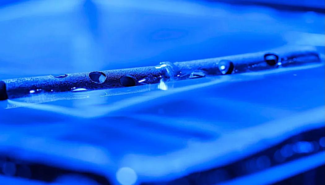 Metal treated with micro- and nanostructures can float on water, even after being drilled with holes. Foto: The University of Rochester