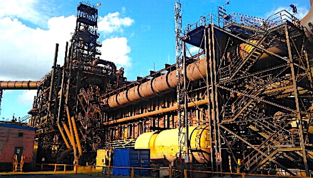 ArcelorMittal Hamburg GmbH operates Western Europe’s only steelworks equipped with this (The picture) type of direct reduction plant. Iron ore pellets are converted into metallic iron using a reducing gas instead of coke. The gas already consists of approximately 60 per cent hydrogen, making complete reduction with hydrogen a possible next step. If the hydrogen were produced through electrolysis powered exclusively by renewable electricity, the resulting production route could be almost free of carbon dioxide emissions. Photo: ArcelorMittal.

