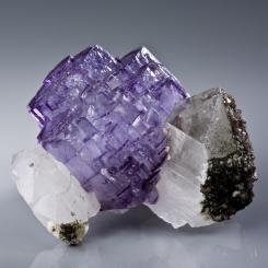 Freestanding purple fluorite cluster between two quartzes. Photo: Rob Lavinsky, iRocks.com/Wikimedia Commons